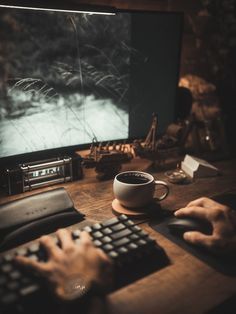 a person sitting at a desk in front of a computer with a keyboard and mouse