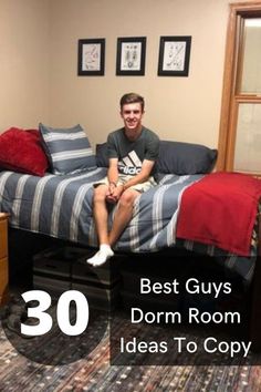 a man sitting on top of a bed in a room with red and blue pillows