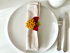 a white plate topped with a flower next to a fork and knife