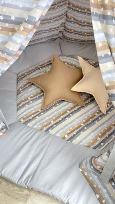 a bed with two pillows on top of it and a star pillow in the middle