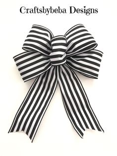 a black and white striped bow with the words craftsbybe designs on it's side