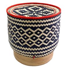 a blue and white basket sitting on top of a wooden stand