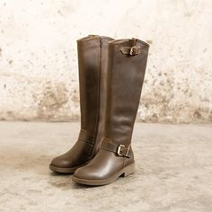 a pair of brown boots sitting on top of a cement floor