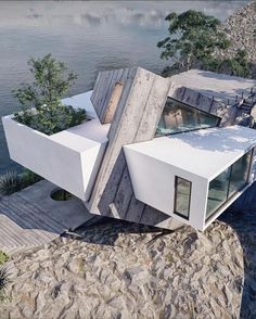 an aerial view of a house built into the side of a cliff overlooking water and trees