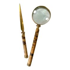 a magnifying glass sitting on top of a wooden stick next to a knife