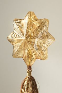 a golden flower with tassels hanging from it