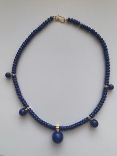 "This necklace is handmade from Lapis Lazuli. These are beautiful quality stones in a rondell shape ( 6mm x 3 mm)  with 5 lapis gem balls 8mm -16mm in size. The necklace is 18 inches long and hand-knotted on gold thread. The clasp is sterling silver plated with 14k gold.  In ancient times Lapis Lazuli was most highly regarded because of its beautiful color and the valuable ultramarine dye and paint color derived from it. Its name comes from the Latin lapis, \"stone,\" and the Persian word \"blue Lapis Lazuli Round Beaded Necklaces, Lapis Lazuli Necklaces With 8mm Beads, Lapis Lazuli Necklace With 8mm Beads, Necklace With 8mm Round Lapis Lazuli Beads, Elegant Lapis Lazuli Beaded Necklaces With Round Beads, Elegant Beaded Necklaces With Round Lapis Lazuli Beads, Elegant Lapis Lazuli Beaded Necklace With Round Beads, Elegant Lapis Lazuli Beaded Necklaces, Elegant Lapis Lazuli Beaded Necklace