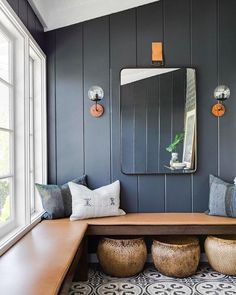 a wooden bench sitting under a large mirror in a room with blue walls and flooring