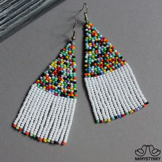 These white and colorful beaded earrings are made of high-quality Czech beads and strong synthetic thread. They are elegant, fashionable, and highly versatile, suitable for everyday wear. Features: Sterling silver components Color: white, colorful mix Length (approximate): 7.5 cm (2.95 in) This item is currently in stock. More beaded earrings http://etsy.me/2ycItdb Gerdan necklaces http://etsy.me/2mihf0J Beaded necklaces http://etsy.me/2Dkf1Fo Crochet necklaces http://etsy.me/2CAPdFc Back to sho Seed Bead Jewelery, Beaded Earrings Native American, Long Turquoise Earrings, Beard Jewelry, Boho Chandelier, Turquoise Bead Earrings, Blue Beaded Earrings, Earrings Native American, Seed Bead Crafts