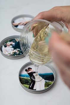 a person is holding a wine glass in front of some coasters with pictures on them