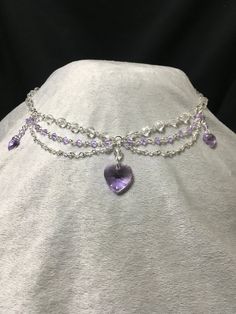 Elegant and dainty necklace made using violet Swarovski bicone beads and featuring three violet Swarovski heart pendants. Necklace is 19.5 inches long, with a lobster clasp closure. Silver Crystal Heart Necklace For Wedding, Crystal Jewelry With Heart Charm For Valentine's Day, Valentine's Day Crystal Jewelry With Heart Charm, Crystal Heart Cut Jewelry With Heart Charm, Crystal Double Heart Necklaces For Wedding, Crystal Heart Pendant Necklace For Party, Crystal Double Heart Jewelry For Wedding, Crystal Heart Pendant Necklace For Wedding, Elegant Heart Necklace With Rhinestones For Parties