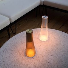 two vases sitting on top of a white table