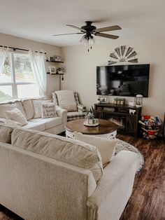 a living room filled with furniture and a flat screen tv mounted to the side of a wall