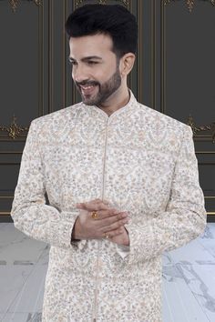 This groom sherwani, with elegant thread embroidery and shimmering stones, exudes luxury and sophistication. Elevate your special day with this exclusive piece, reminiscent of the finest art and literature. Make a statement and stand out as the most stylish groom in this Mens Sherwani, the perfect blend of tradition and modernity. Bollywood Style Sherwani With Intricate Embroidery For Formal Occasions, Fitted Sherwani With Pearl Embroidery For Formal Occasions, Formal Fitted Sherwani With Pearl Embroidery, Traditional Nehru Jacket With Pearl Embroidery For Eid, Formal Long Sleeve Kurta With Pearl Embroidery, Elegant Raw Silk Bandhgala With Naqshi, Elegant Fitted Sherwani With Pearl Embroidery, Formal Traditional Wear With Pearl Embroidery, Traditional Nehru Jacket With Intricate Embroidery For Wedding