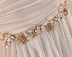 "Elegant Freshwater Pearl floral bridal sash for your most romantic day! This hand wired wedding belt combines soft white enamel flowers, tiny shell flowers Freshwater Pearls, crystal beads and small gold stamped leaves. It brings elegant style to botanical beauty and would be beautiful with many wedding themes. READY TO SHIP DETAILS * Measures aprox.1.5\" wide (at widest part) by 13\" long. * Attached at ends to imported French satin ribbon in choice of colors. * Total sash length 3 yards. * Of Elegant Bridal Belt With Flower Decoration For Wedding, Elegant Bridal Belt With Handmade Flowers For Weddings, Elegant Bridal Belt With Flower Decoration, Elegant Bridal Belt With Handmade Flowers, Crystal Wedding Tiaras, Shell Flowers, Vintage Evening Bags, Wedding Belt, Rose Gold Flower