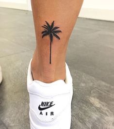 a small palm tree tattoo on the ankle