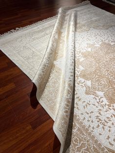 a large white rug sitting on top of a wooden floor