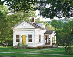 a painting of a small white house with yellow door and windows in the front yard