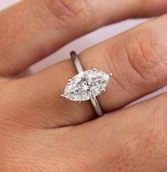 a woman's hand with a diamond ring on top of her finger and an engagement band