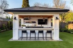 an outdoor bar with four stools in the grass