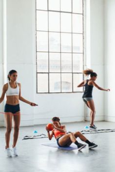 a group of young women doing exercises in an empty room