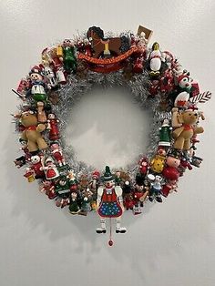 a christmas wreath hanging on the wall next to a white wall with lots of ornaments