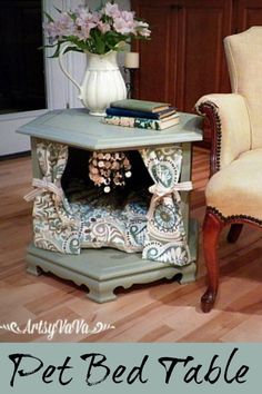 a dog bed table in the middle of a living room with a chair and vase on top