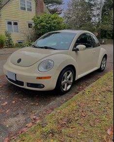 a white car is parked on the side of the road in front of a house