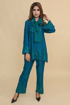 This elegant V-neck embroidered co-ord Set comes handcrafted in a loose-fitting cotton silk fabric laden with embroidery on ghera and sleeves along with embroidered palazzos. Organza stole adds to it elegance. Stylish Coordsets, Embroidered Silk Blue Palazzo Set, Blue Silk Palazzo Set With Intricate Embroidery, Silk Sets With Chikankari Embroidery, Eid Straight Kurta With Resham Embroidery, Eid Resham Embroidery Kurta With Straight Pants, Festive Cotton Silk Pant Set With Chikankari Embroidery, Organza Coordsets, Intricate Embroidery Palazzo Set In Raw Silk