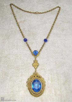 "(Description is below) ALL DELIVERY DATES mentioned by Etsy are ESTIMATES, no delivery date or range is guaranteed, though most of our orders arrive ahead of estimate.  LAYAWAY IS AVAILABLE, typically with a 20% deposit. Please contact us to arrange.  Old, probably late 19th or early 20th century, brass filigree and faceted blue glass pendant necklace in a transitional Victorian / Edwardian style. The largest portion of pendant measures about 2.25\", with a total center drop of just over 4\", t Blue Brass Jewelry For Wedding, Vintage Blue Jeweled Necklaces, Blue Bohemian Jewelry With Locket, Blue Bohemian Locket Jewelry, Bohemian Blue Locket Jewelry, Blue Antique Jewelry With Antique Finish, Antique Blue Brass Jewelry, Blue Antique Finish Jewelry For Gift, Blue Antique Finish Jewelry Gift