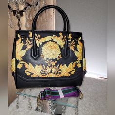 This Show Stopper Handbag Or Shoulder Is Bright Yellow And Black Floral Design With A Black Medallion On The Front Closure. Very Spacious On The Inside For All Of Your Essentials. Great Colors For Spring And Summer But Is Designed For All 4 Seasons. Comes With 2 Different Types Of Straps For A Shoulder Bag. Excellent Quality. New With Tags And Duster Bag. Height:11" Length:13" Depth:5 1/2 " Designer Yellow Bag With Top Carry Handle, Luxury Yellow Bag With Top Carry Handle, Luxury Yellow Crossbody Satchel, Luxury Yellow Rectangular Shoulder Bag, Luxury Yellow Rectangular Bags, Designer Yellow Satchel With Double Handle, Luxury Yellow Tote Bag, Designer Yellow Satchel With Removable Pouch, Designer Yellow Satchel With Detachable Strap