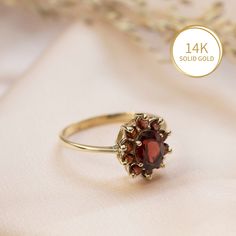 Elegant Garnet Flower ring in 14k yellow gold, multi stone halo engagement, wedding or promise ring for women.   This beautiful handmade ring is made of solid 14k yellow gold and is set with a faceted oval garnet, surrounded by a halo of 10 faceted smaller round garnets. The deep red of the gemstones combined with the classic halo design give this ring a regal look that cannot be ignored.   Garnet is January's birthstone.  This ring can be a wonderful engagement/promise/wedding ring, or a gift f Heirloom Red Birthstone Ring, Red Cluster Ring With 17 Jewels For Wedding, Red 14k Gold Ring Gift, Heirloom Cluster Ring Gift, Birthstone Cluster Ring Gift, 14k Gold Red Diamond Ring For Anniversary, Heirloom Style Red Birthstone Ring For Gift, Anniversary 14k Gold Diamond Ring In Red, Heirloom Red Birthstone Promise Ring