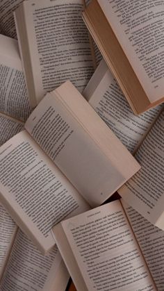 several open books laying on top of each other in the middle of a pile,