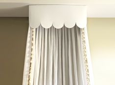 a white curtain hanging on the side of a wall