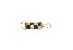 a black and white striped keychain hanging from a hook on a white background