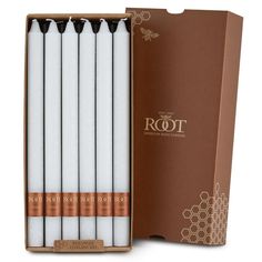 four white candles in a brown box