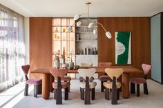 a dining room table with chairs and a painting on the wall