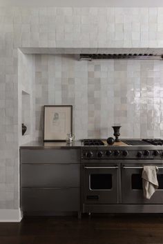 a stove top oven sitting inside of a kitchen next to a wall mounted pot rack