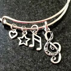 New Music Note Charm Bracelet Adorned With Two Music Note Charms, A Star And A Heart Charm Silver Plated Adjustable Wire Bracelet Fits Wrists 5.5 To 8.5 Inches Ships Within 24 Hours Of Purchase Monday-Saturday Adjustable Silver Jewelry For Concert, Adjustable Silver Jewelry For Concerts, Silver Band Jewelry For Concert, Silver Band Jewelry For Concerts, Adjustable Music-themed Bracelets For Concerts, Silver Band Bracelets For Concerts, Adjustable Silver Bracelets For Concerts, Adjustable Metal Bracelets For Concerts, Silver Metal Bracelets For Concert