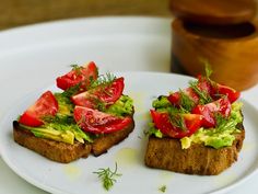 two pieces of bread with tomatoes and avocado on top