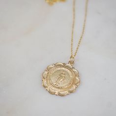 A whimsical, meaningful pendant chain. Scalloped trim medallion of Mother Mary, with tiny inscriptions on front of medal. Material: 14/20 Gold Filled Chain & Findings Length: 18" Charm: 22mm width - 14/20 Gold-Filled Gold Coin Jewelry, Miraculous Medal, Scalloped Trim, Coin Jewelry, St Mary, Mother Mary, Gold Coins, Gold Filled Chain, Jump Rings