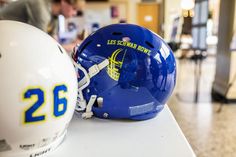 a football helmet sitting on top of a table next to a white and blue ball