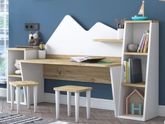 a child's desk with bookshelf and stools in front of a blue wall