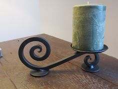 a candle is sitting on top of a table with a metal holder next to it