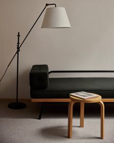 a living room with a couch, table and lamp on the floor next to it