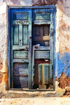 an old wooden door with blue paint on it