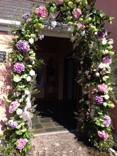 an archway decorated with flowers and greenery