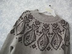 a gray sweater with black and white designs on it