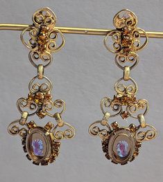 "Vintage 1960s era signed Celebrity by Juliana statement earrings. These are such beautiful and ornate earrings. Earrings feature glass cameos prong set in filigree goldtone with citrine rhinestones also prong set. Earrings are clip back style. Earrings are fully hallmarked and will arrive gift boxed. MARKS Celebrity on clip backs. CONDITION In very good to excellent condition. Please use all pictures as part of item's description. SIZE  2 7/8\" x 1 1/4\". MATERIALS Glass, Goldtone, Rhinestones. Victorian Dangle Chandelier Earrings For Parties, Vintage Formal Filigree Chandelier Earrings, Victorian Chandelier Dangle Earrings For Party, Formal Vintage Chandelier Earrings, Victorian Style Party Chandelier Earrings, Retro Dangle Jewelry For Formal Occasions, Vintage Chandelier Earrings For Evening, Antique Chandelier Earrings For Formal Occasions, Victorian Chandelier Drop Earrings For Evening