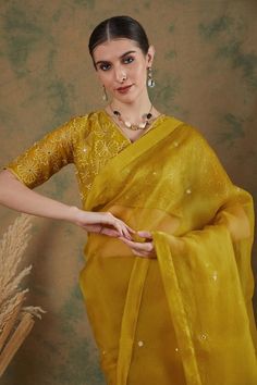 Golden yellow silk organza saree with mirror embroidery. Comes with thread embroidered blouse.
Components: 2
Pattern: Embroidered
Type Of Work: Mirror, Floral
Neckline: V Neck
Sleeve Type: Half
Fabric: Silk organza
Color: Gold,Yellow
Other Details: 
Note: Petticoat worn by the model is not for sale.
Occasion: Wedding - Aza Fashions Traditional Organza Blouse For Festive Occasions, Designer Cutdana Organza Blouse, Designer Organza Blouse With Cutdana, Diwali Sheer Dupatta Blouse In Dola Silk, Green Organza Blouse With Resham Embroidery, Diwali Blouse In Organza With Traditional Drape, Diwali Organza Blouse With Zari Work, Traditional Drape Organza Blouse With Cutdana, Diwali Organza Blouse With Traditional Drape